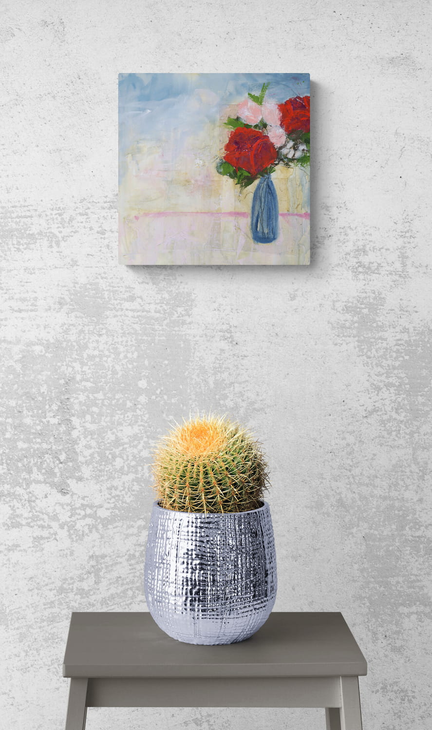 Original mixed media art in room by Little Haven Art Studio depicting romantic roses in pink, red, and blue, hanging on wall above planted cactus on table.