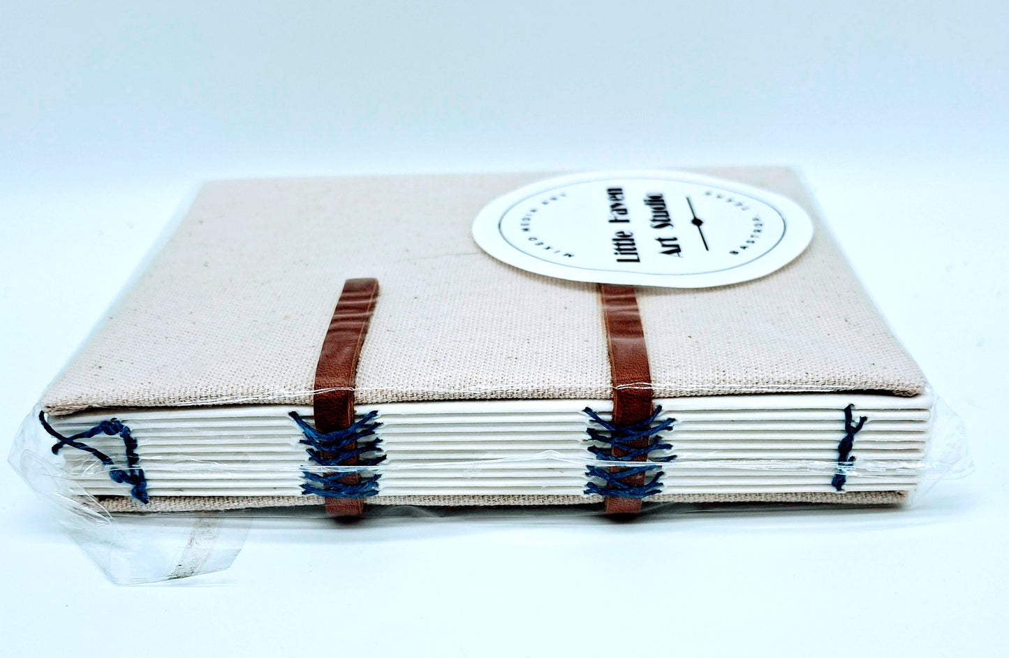 Handmade art journal 6" x 4.5" x 1" with brown canvas cover and blue thread made by Amanda Craig of Little Haven Art Studio.