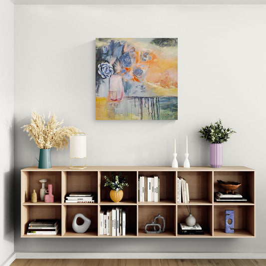"Finding Joy" by Amanda Craig hanging on wall above cabinet holding collected artistic items.