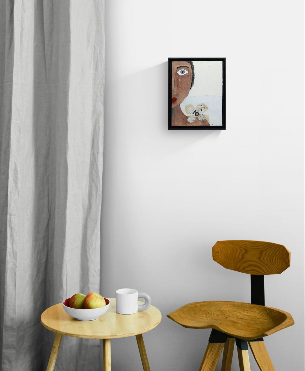 Original mixed media wall art, titled "Sadness" in the Beauty for Ashes series by Little Haven Art Studio, depicting half of a face displaying sad feelings with a tear, with flower collage and plaster elements, hanging above wood table and chair.