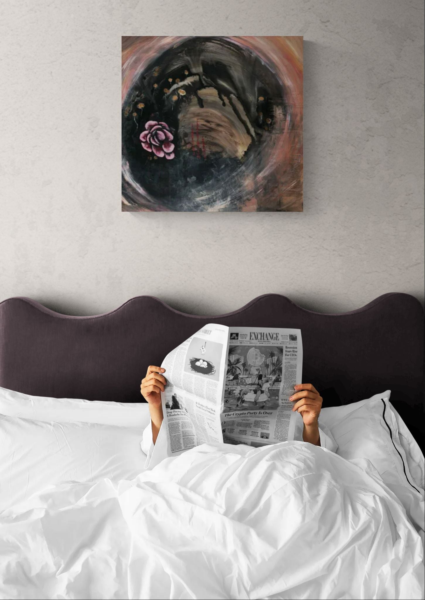 Abstract original meditative pink wall art, titled "Gold Dandelion" by Little Haven Art Studio with a pink flower, gold dandelions, and swirling background in bedroom above person reading a newspaper.