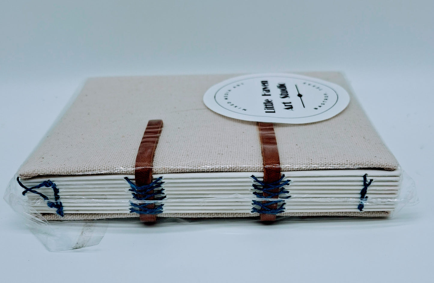 Handmade art journal 6" x 4.5" x 1" with brown canvas cover and blue thread made by Amanda Craig.