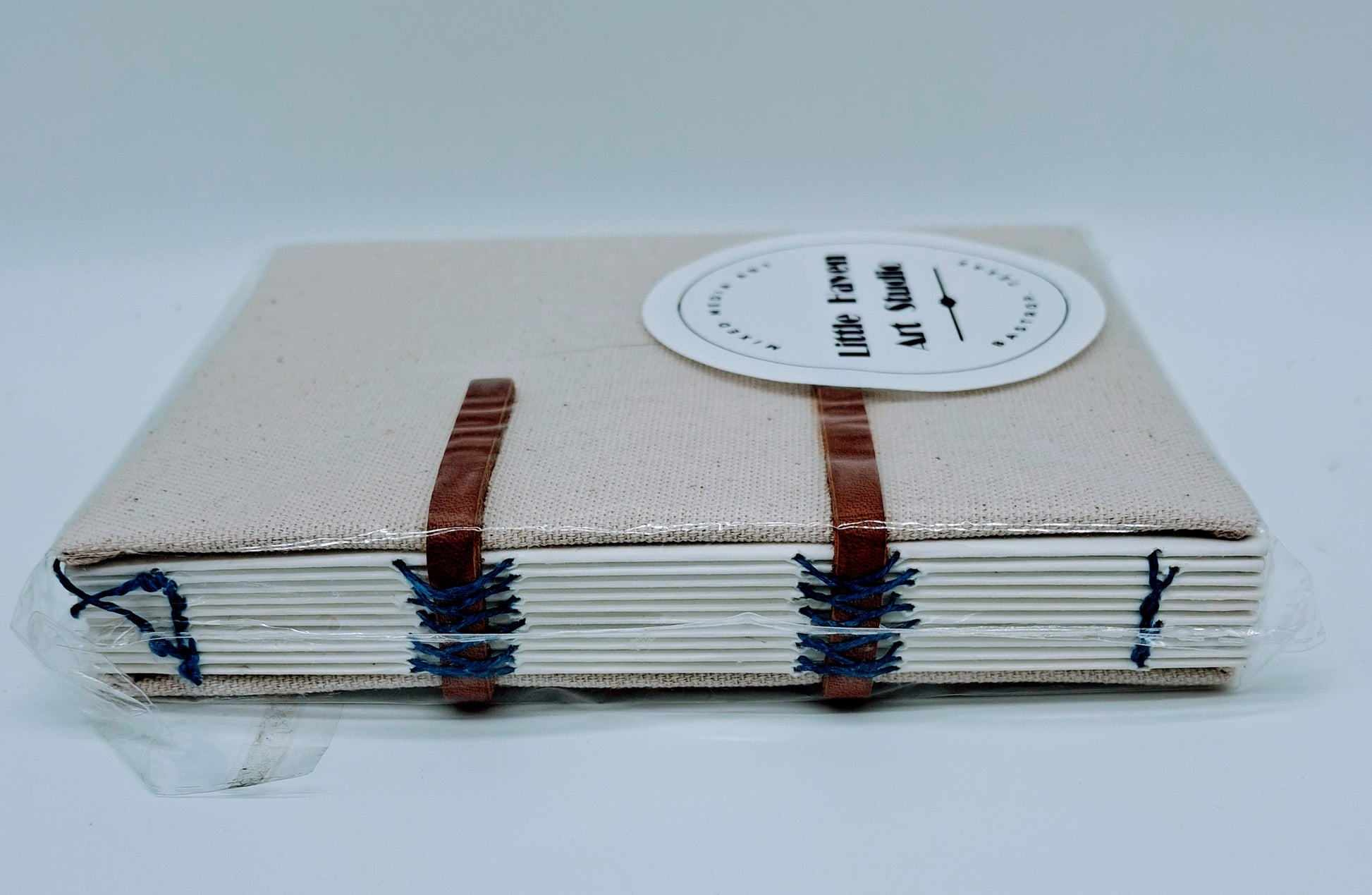 Handmade art journal 6" x 4.5" x 1" with brown canvas cover and blue thread made by Amanda Craig.
